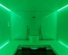 Zeleno osvetlená parná kabína s lavicami a nádobou uprostred.