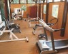Malá telocvičňa s rôznym fitness vybavením a drevenou podlahou.