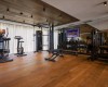 Moderné fitness centrum s rôznym cvičebným vybavením na drevenej podlahe.