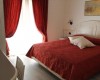 Spálňa s červeným závesom a prikrývkou.