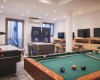 Herná miestnosť s biliardovým stolom, stolným futbalom, air hokejom a videohernými konzolami.