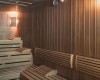 Vnútro drevenej sauny s lavicami a nástenným osvetlením.