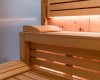 Drevená sauna s lavicami a jemným osvetlením.