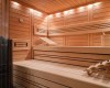 Interiér drevenej sauny s lavičkami a vedrom.