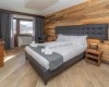 Moderná spálňa s drevenými stenami a veľkou posteľou.