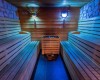 Drevená sauna s osvetlením a lavicami na oboch stranách.