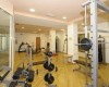 Posilňovňa s rôznym cvičebným vybavením, vrátane činiek a bežeckých strojov.