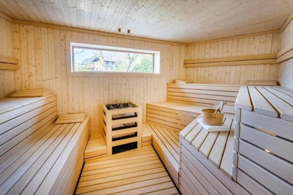 Drevená sauna s lavičkami a oknom.