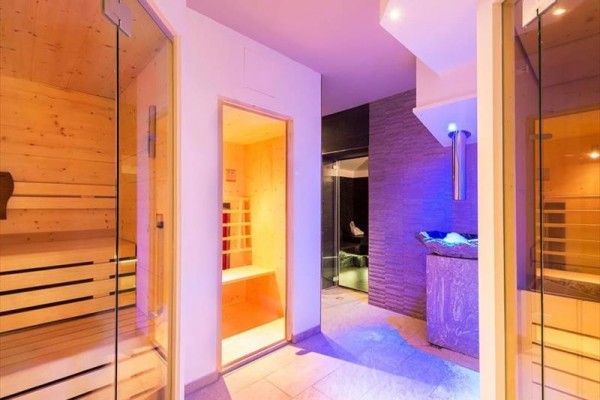 Sauna a wellness miestnosť s moderným osvetlením a dreveným interiérom.