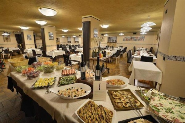 Reštauračná jedáleň s bufetovým stolom plným jedla.