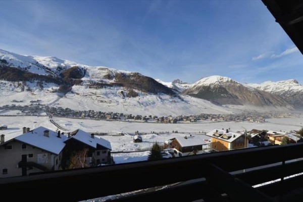 Zimná krajina s horami a dedinou v údolí.