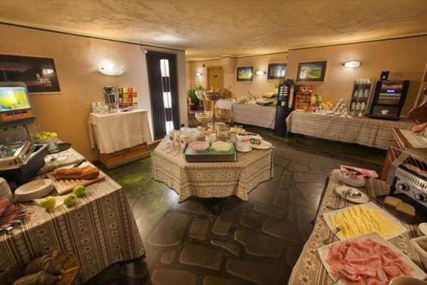 Bufetové raňajky s rôznymi jedlami na stoloch v hotelovej jedálni.