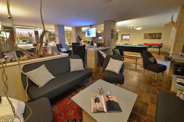 Elegantný salónik s pohovkami a biliardovým stolom.