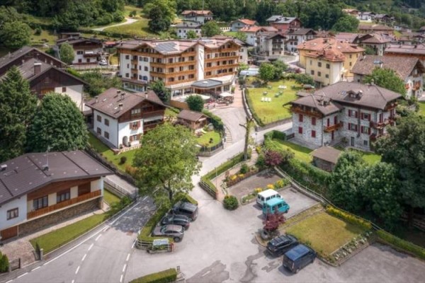 Letecký pohľad na malebnú alpskú dedinu s domami a zeleňou.
