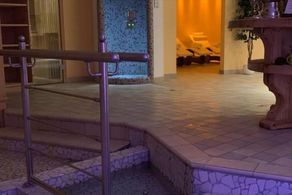 Oddychová zóna s lehátkami a mozaikovou stenou v wellness centre.