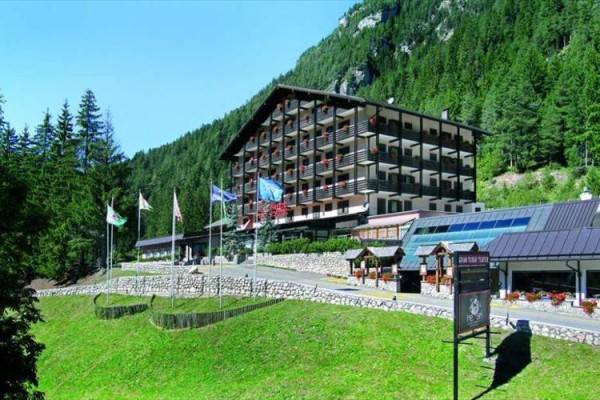 Hotel obklopený zelenými lesmi v horskej krajine.