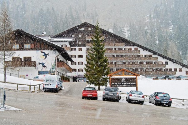 Horský hotel s parkoviskom pokrytým snehom.