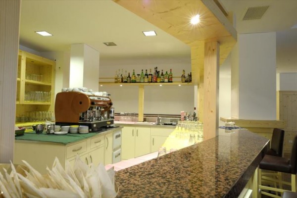 Moderný bar s mramorovým pultom a kávovarom na vzdušnom, svetlom osvietenom mieste.