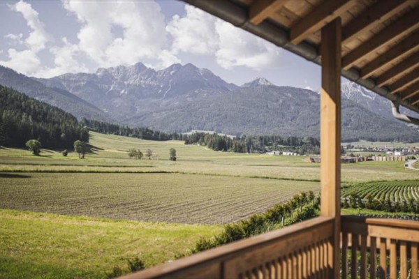 Výhľad z verandy na polia a horskú panorámu v diaľke.