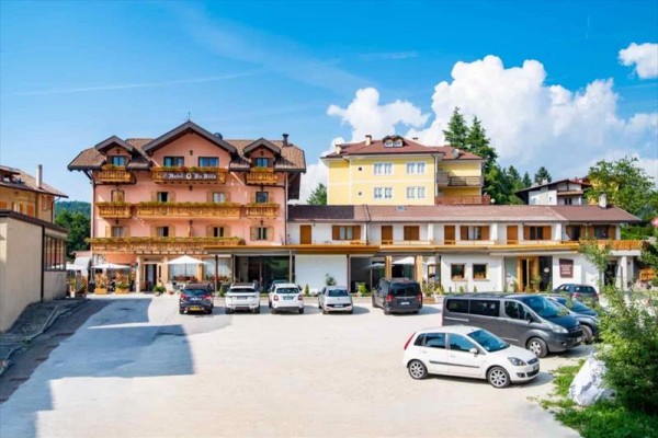 Hotel s parkoviskom a pokojnou krajinou pod modrou oblohou.