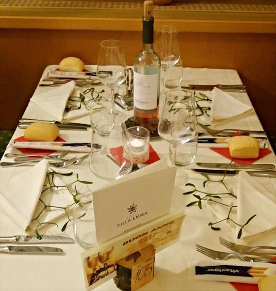 Elegantne prestretý stôl s vínom, pohármi, sviečkou a dekoráciou.