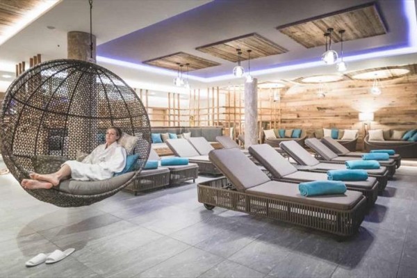 Osoba v župane relaxuje na závesnom kresle v modernom wellness centre.