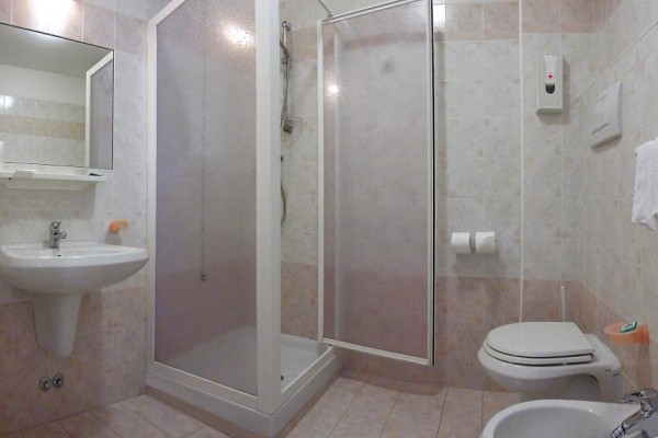 Kúpeľňa s umývadlom, sprchovacím kútom, toaletou a bidetom.