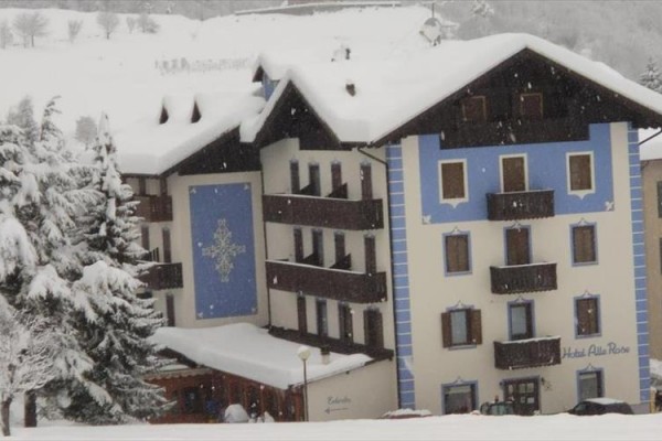 Hotel v zasneženej zimnej krajine so zdobením na fasáde.