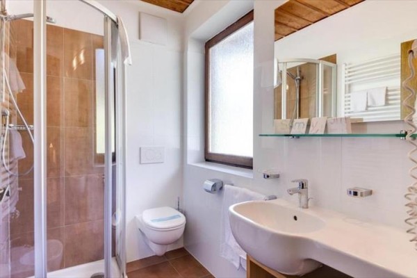 Moderná kúpeľňa s toaletou, sprchovým kútom a umývadlom.  