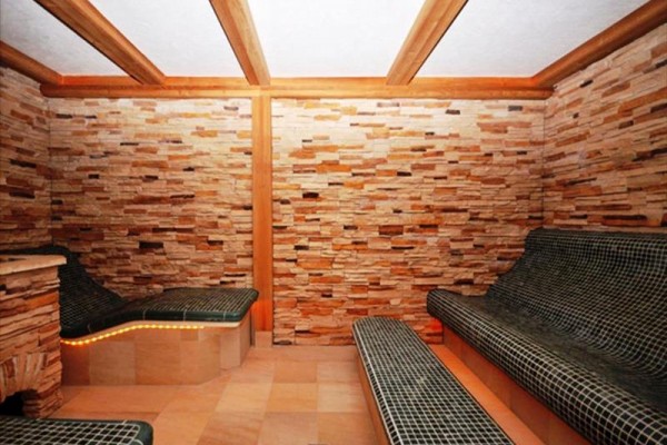 Miestnosť s keramickými ležadlami a stenami z prírodného kameňa.