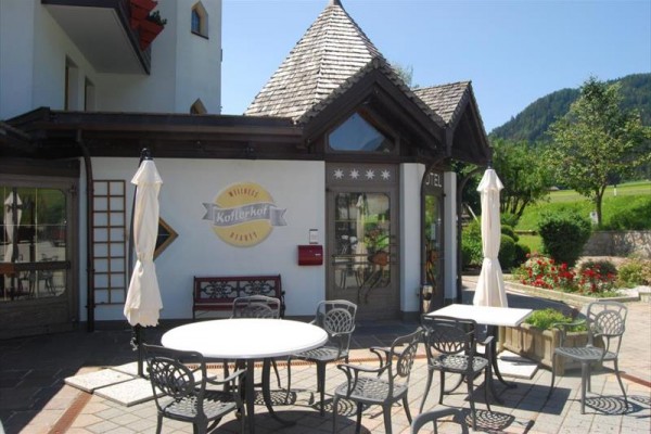 Exteriér kaviarne s vonkajším posedením a horami v pozadí.