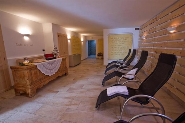 Relaxačná miestnosť s lehátkami a drevenou komodou.