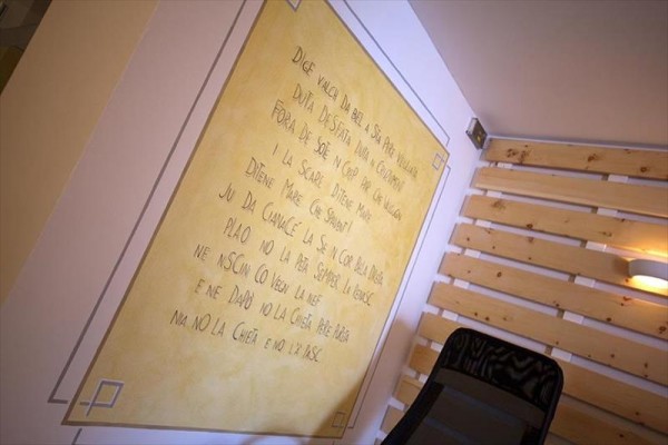 Stena pokrytá dreveným obkladom a žltou plochou s nápisom v cudzom jazyku.