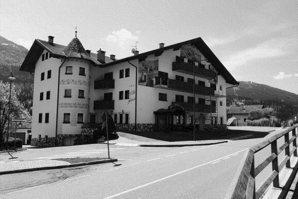 Tradičná viacposchodová budova s vežičkou na vidieckej ceste.