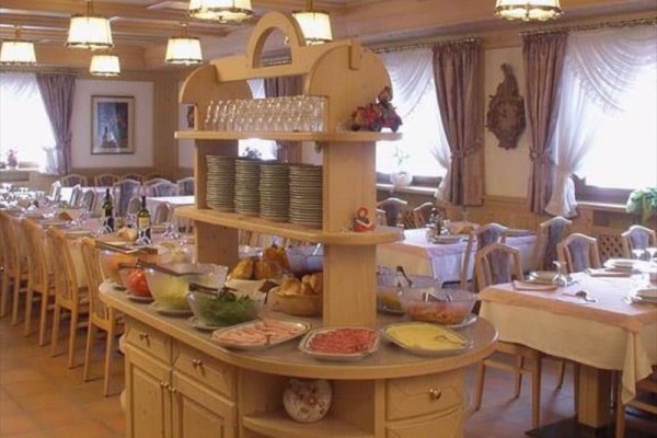 Bufetový stôl s jedlom a riadom vo veľkej jedálni.