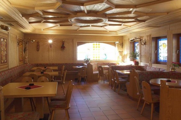 Drevom obložená útulná reštaurácia so stolmi a stoličkami.