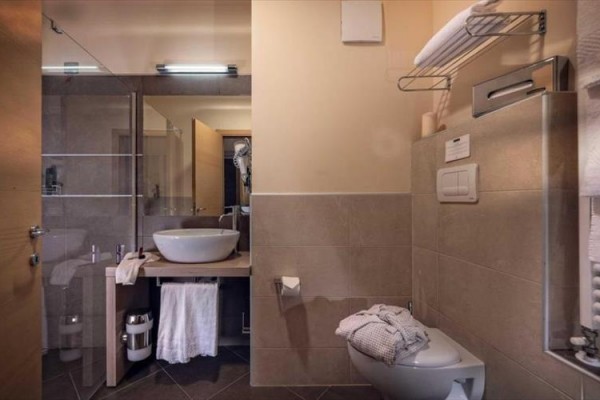 Moderná kúpeľňa s umývadlom, sprchovacím kútom a toaletou v svetlých tónoch.