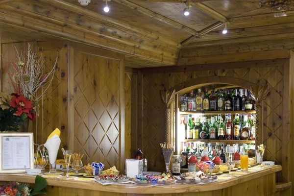 Drevený bar s nápojmi, pohármi a občerstvením.