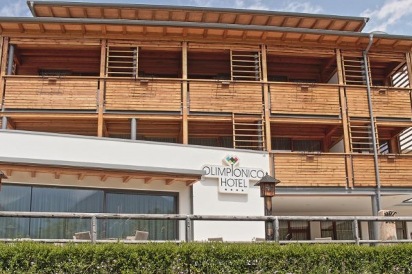 Hotel Olympionico s dreveným balkónom a stenami.