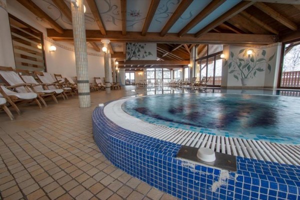 Interiér wellness centra s bazénom a ležadlami.