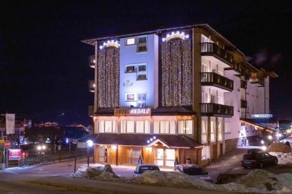 Hotel osvetlený v noci s vianočnými svetlami na fasáde.  
