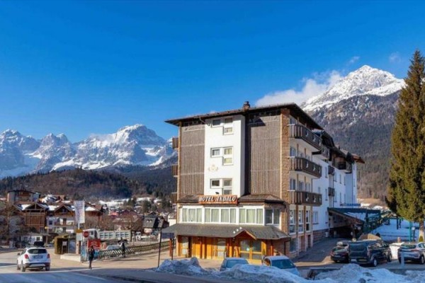 Hotel v horskej oblasti so zasneženými vrcholmi v pozadí.
