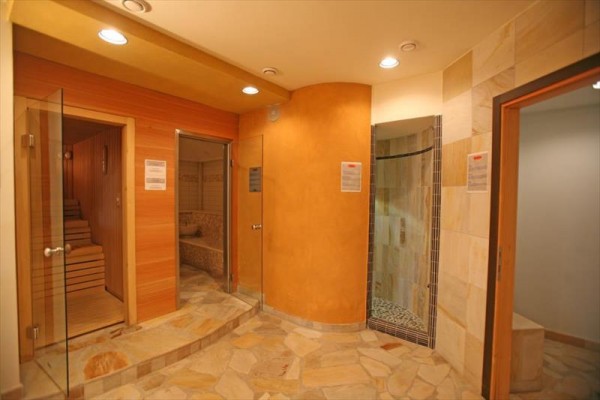 Sauna s dreveným interiérom a priľahlou sprchou.