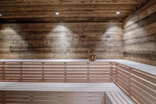Moderná sauna s drevenými stenami a lavicami.