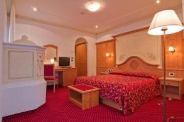 Hotelová izba s červeným kobercom a dreveným nábytkom.  