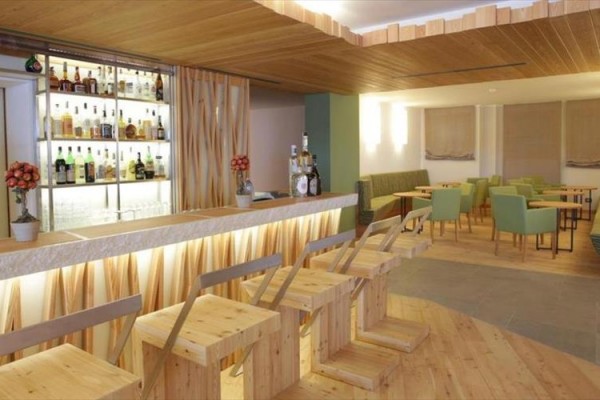 Moderný bar s drevenými stoličkami a stolmi.