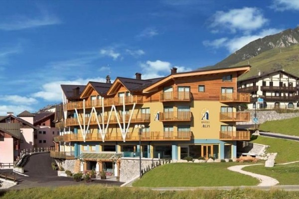 Horský hotel s drevenými balkónmi na svahu.