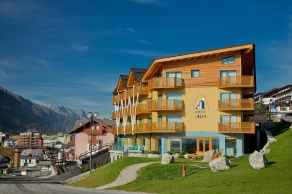 Moderný hotel s drevenými balkónmi na horskom svahu.