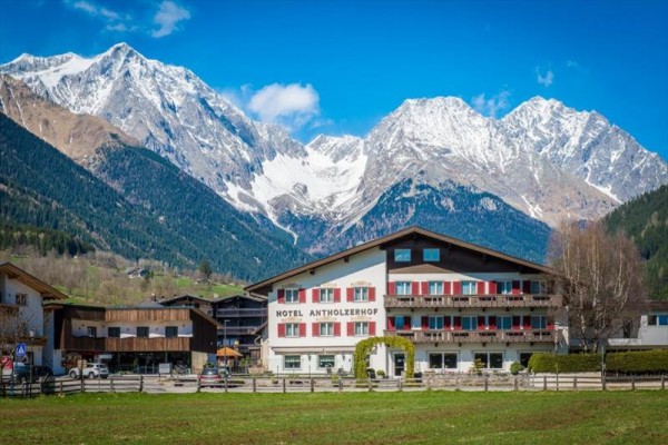 Hotel v horskej krajine so zasneženými vrcholmi v pozadí.  