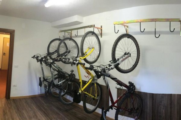 Bicykle zavesené na hákoch na stene v miestnosti.